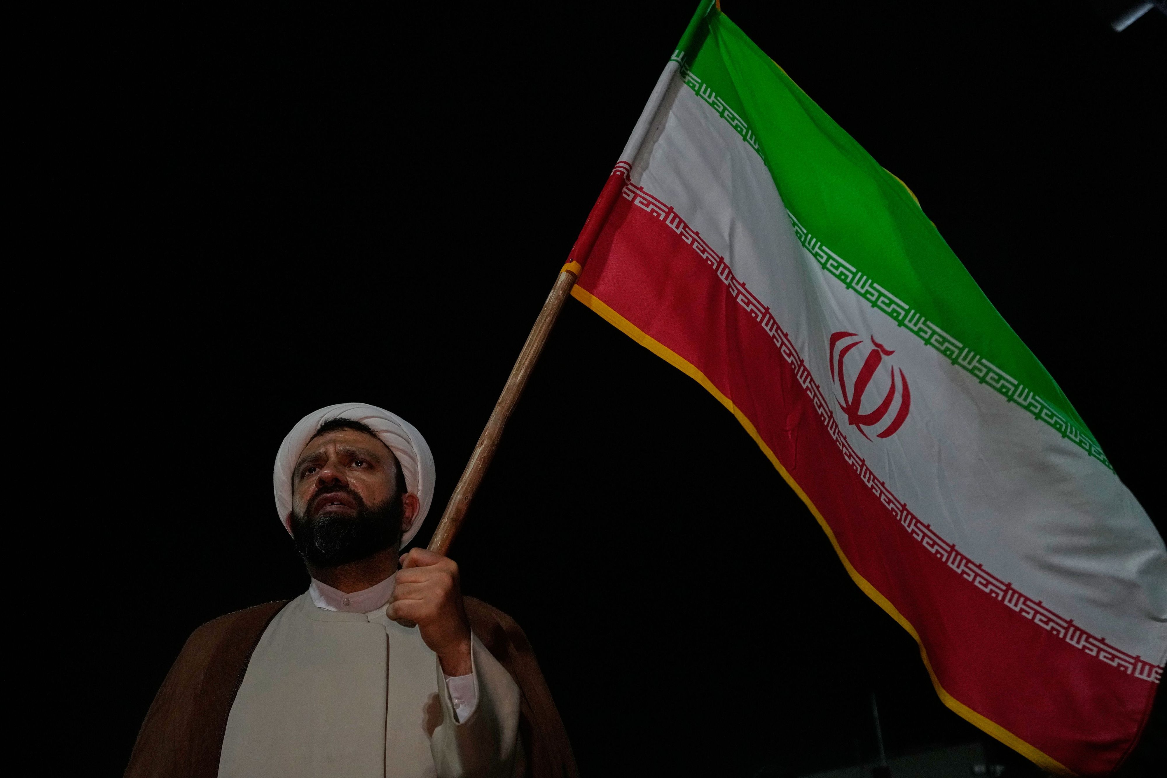 https://images.handelsblatt.com/gHU1pcF2RjkE/cover/4000/2667/0/0/0/0/0.541/0.315/a-cleric-holds-an-iranian-flag-in-a-pro-government-gathering-at-a-square-in-tehran-iran-friday-ma.jpg